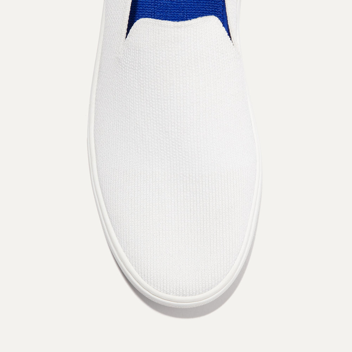 The slip-on Sneaker in Bright White shown from the top view with detailing of the front of the shoe.