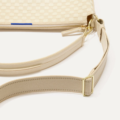 The Mini Zip Bucket in White Sand lying flat, shown at a diagonal view from the left.