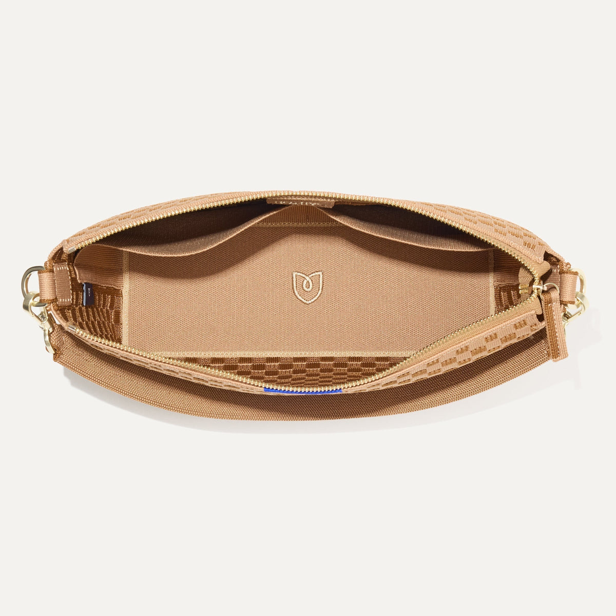 The Daily Crossbody Bag in Hazelnut shown from the top down, with zipper open and interior exposed.