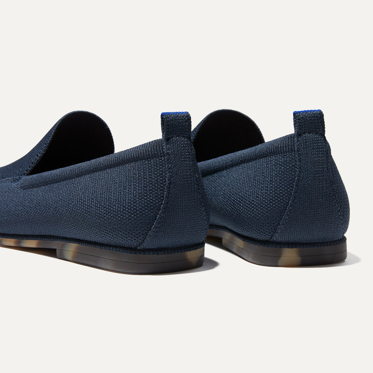 Close up of the heel of The Ravello Loafer in Navy, with Rothy's signature blue halo on the pull tab.
