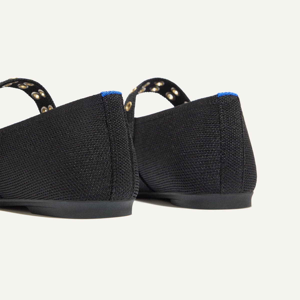 Close up of the heel of The Max Buckle Mary Jane in Black, with Rothy's signature blue halo.