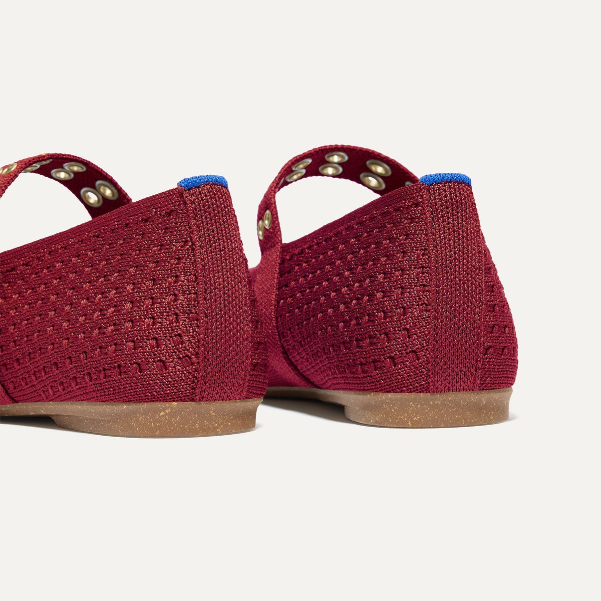 Close up of the heel of The Max Buckle Mary Jane in Ruby Mesh, with Rothy's signature blue halo.