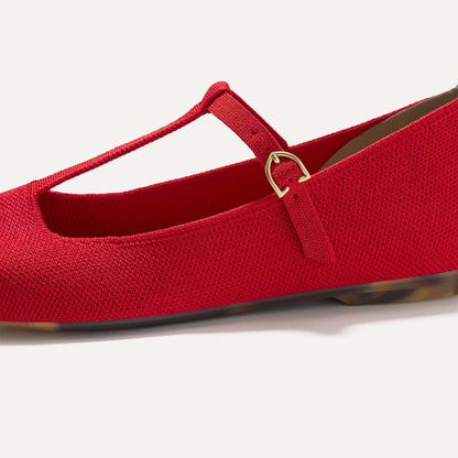 Close up of the T-shaped strap and adjustable buckle of The T-Strap Mary Jane in Red Crisp.