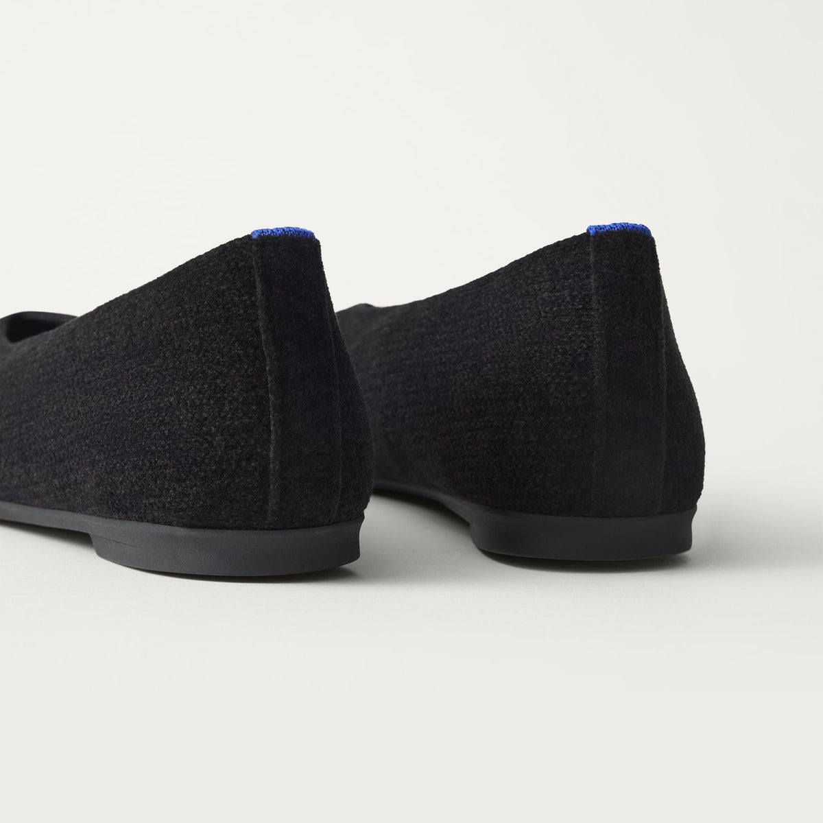Close up of the heel of The Max Square Ballerina in ReVelvet Black with Rothy's signature blue halo.